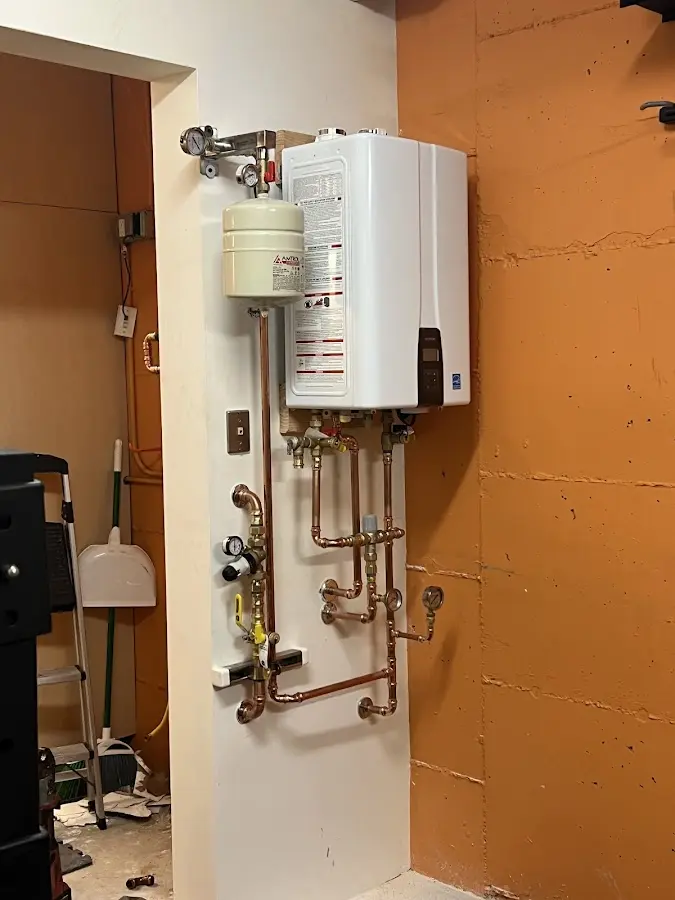 Plumbing technician inspecting water heater connections in Bowling Green